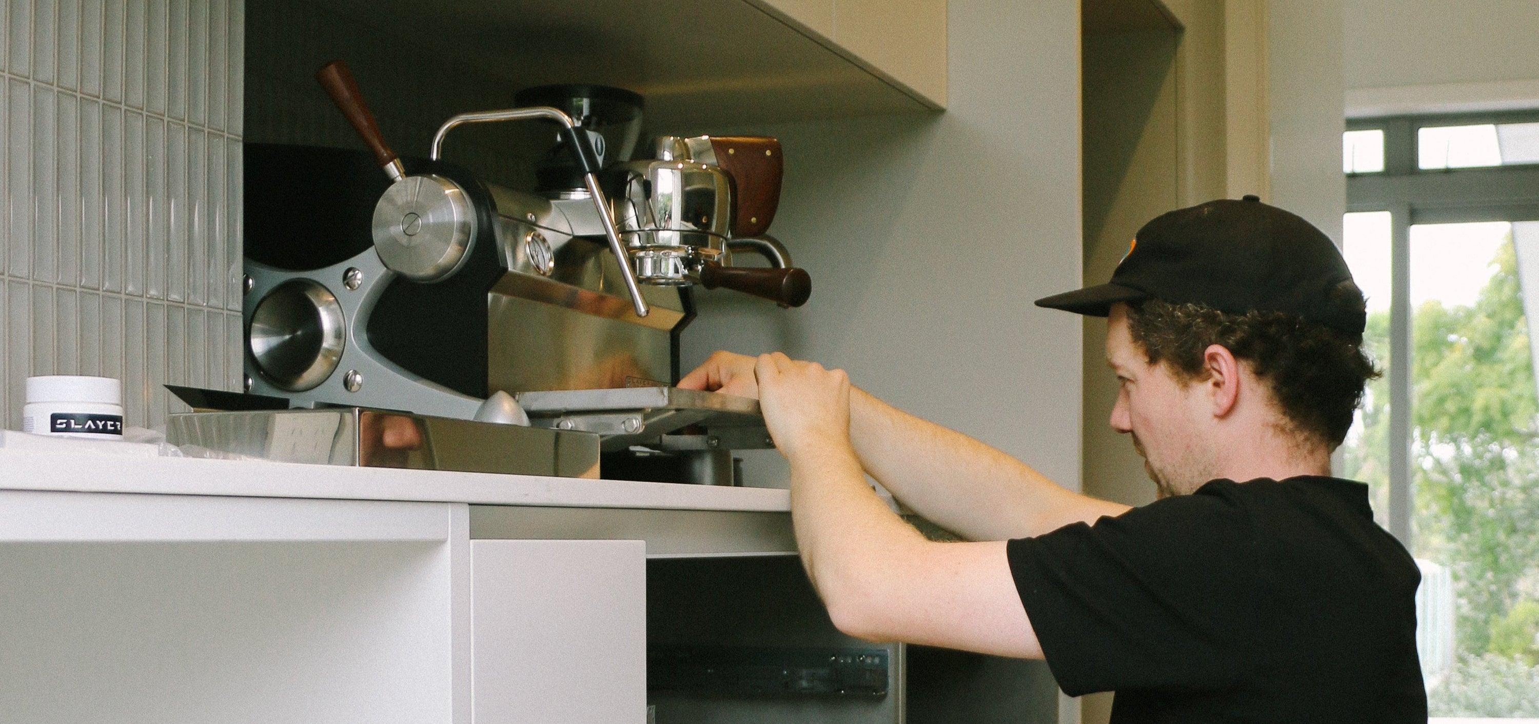 Technician repairing a coffee machine in a home kitchen setting