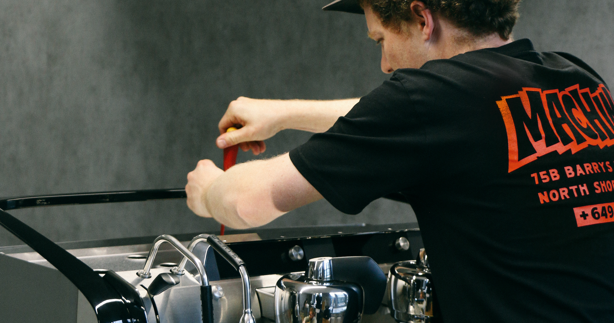 Espresso technician servicing a commercial coffee machine.