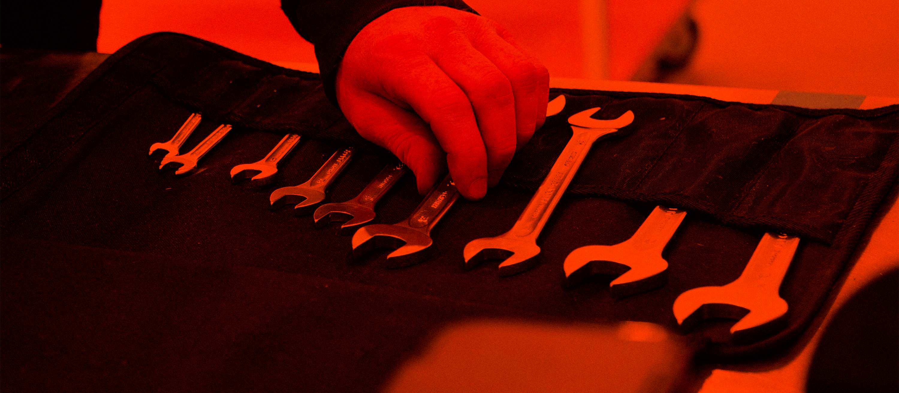 espresso technician's handing picking up a wrench